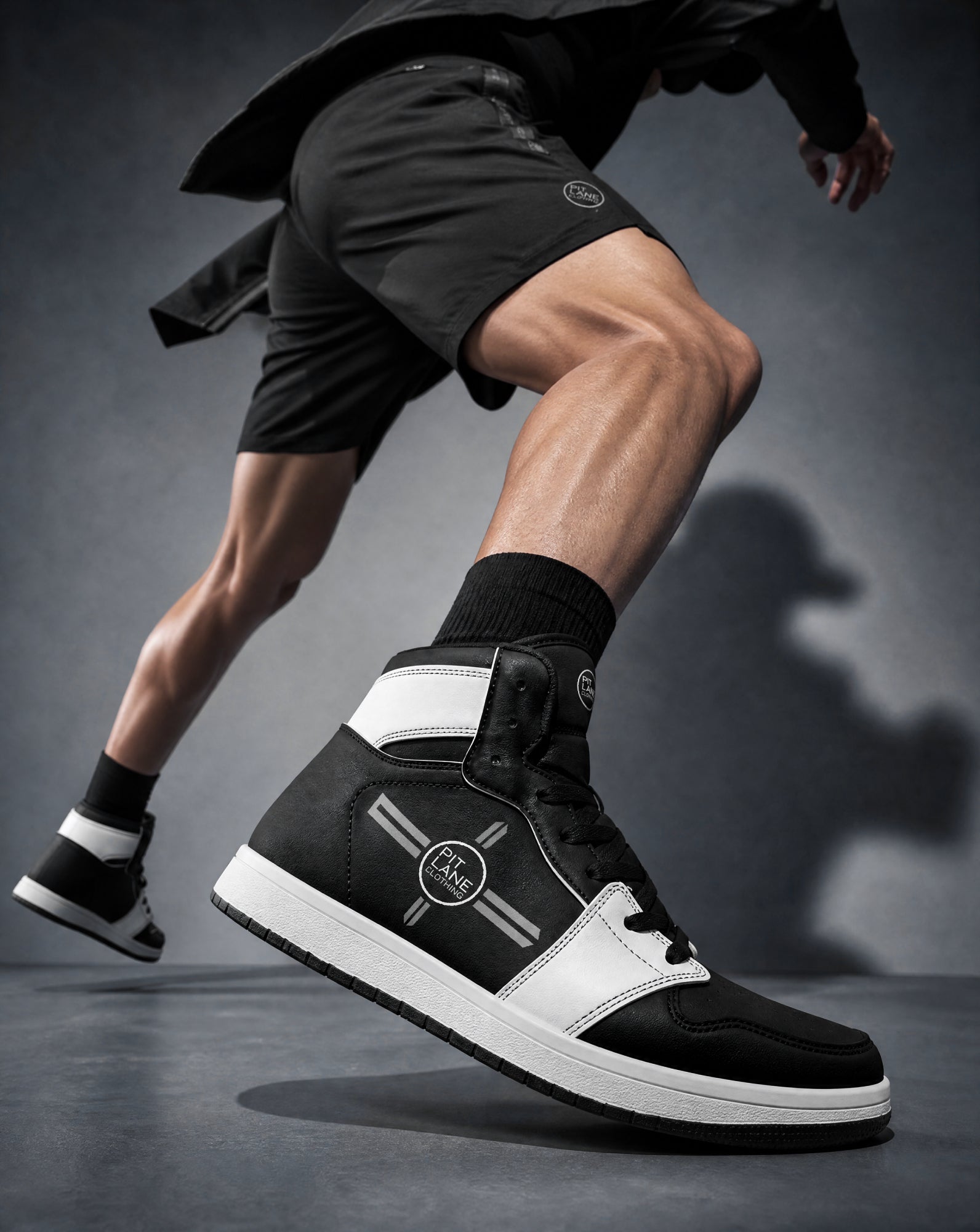 A man wearing PIT LANE CLOTHING sneakers
