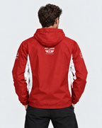 A man viewed from behind wearing a red hooded jacket with white side panels and a white 'PIT LANE CLOTHING' logo on the back, paired with black pants against a light gray studio background.