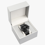 A black Pit Lane Clothing stainless steel watch with a matching black metal link bracelet, featuring a black dial with white Arabic numerals and hands, set against a neutral gray background.