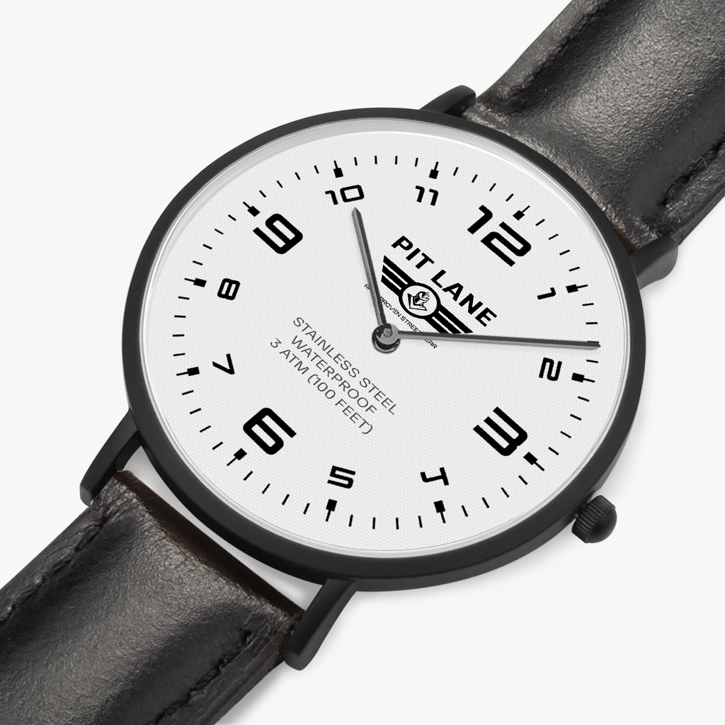 A Pit Lane wristwatch with a black leather strap, black case, and a white dial with black Arabic numerals, shown against a light gray background.