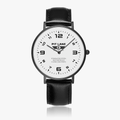 A Pit Lane wristwatch with a black leather strap, black case, and a white dial with black Arabic numerals, shown against a light gray background.