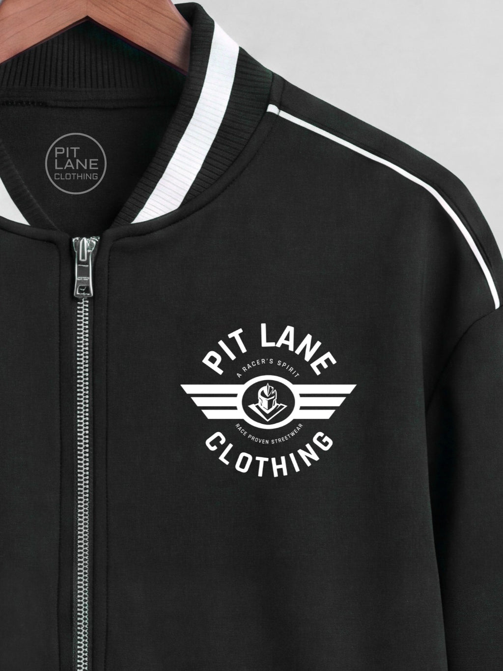 Black zip-up jacket with white contrast trim on the collar and shoulders, featuring a white 'PIT LANE CLOTHING' wing logo printed on the left chest.