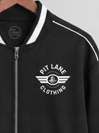 Black zip-up jacket with white contrast trim on the collar and shoulders, featuring a white 'PIT LANE CLOTHING' wing logo printed on the left chest.