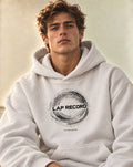 A white pullover PIT LANE CLOTHING hoodie with a distressed white graphic on the chest reading 'LAP RECORD' and smaller text below, shown on a plain white background.