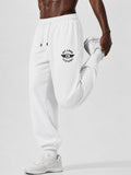 White jogger sweatpants with a black 'Pit Late Clothing' logo on the left thigh, modeled by a man performing a leg raise against a light gray studio background.