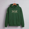 A dark green pullover hoodie hanging on a wooden hanger against a light gray wall. The hoodie features a beige graphic on the chest with the text 'PIT LANE' and 'RACE PROVEN' beneath it, and a matching graphic on the left sleeve.