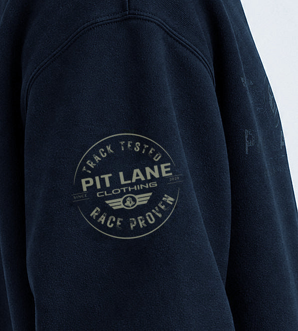 Close-up of a dark navy sweatshirt sleeve featuring a circular 'Pit Lane Clothing' graphic printed in a faded off-white color on the upper arm.