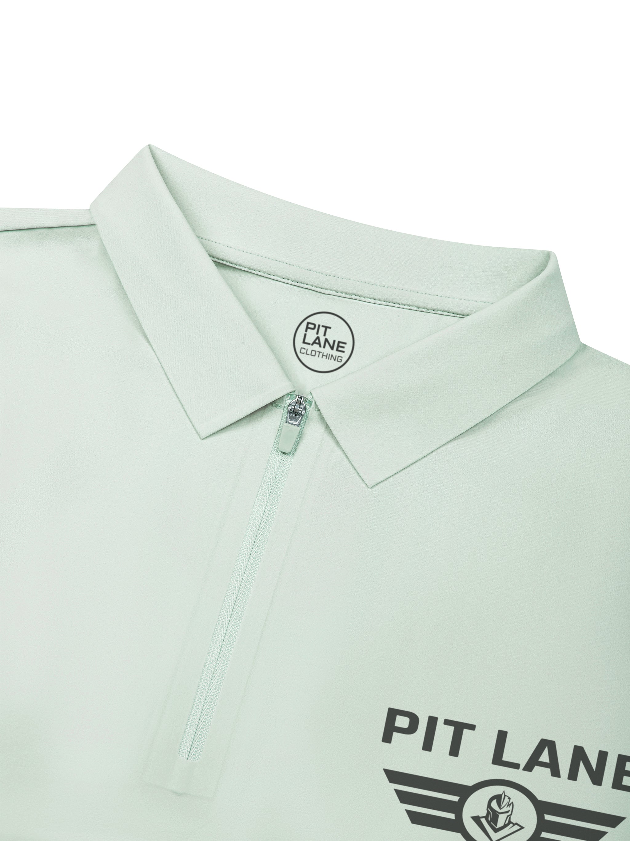 A close-up of a mint green polo shirt by Pit Lane, showing the collar, a partial zipper, and the Pit Lane logo printed on the chest.