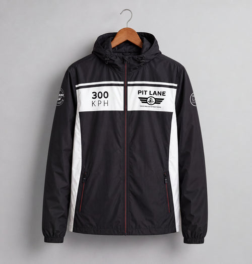 A black hooded windbreaker jacket with white side panels and a white chest stripe, hanging on a wooden hanger against a light gray background. The chest features '300 KPH' and 'PIT LANE CLOTHING' graphics.