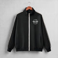 A black zip-up track jacket with a white front zipper, white shoulder stripes, and a white 'PIT LANE CLOTHING' wing logo on the chest, hanging on a wooden hanger against a light gray background.