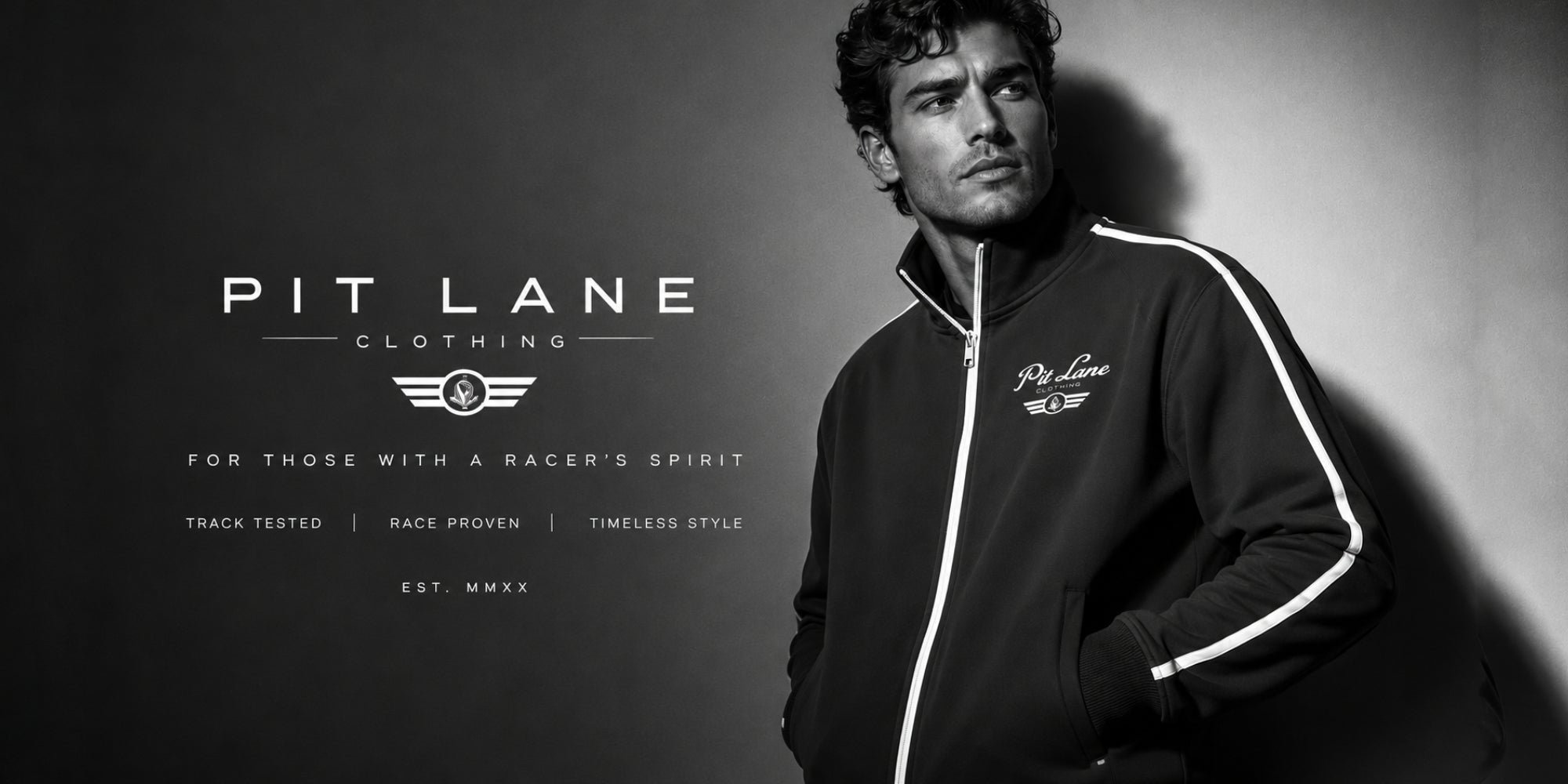 A man wearing a black Pit Lane Clothing Racing track jacket with white stripe details on the sleeves, posed against a dark studio background with brand text on the left.