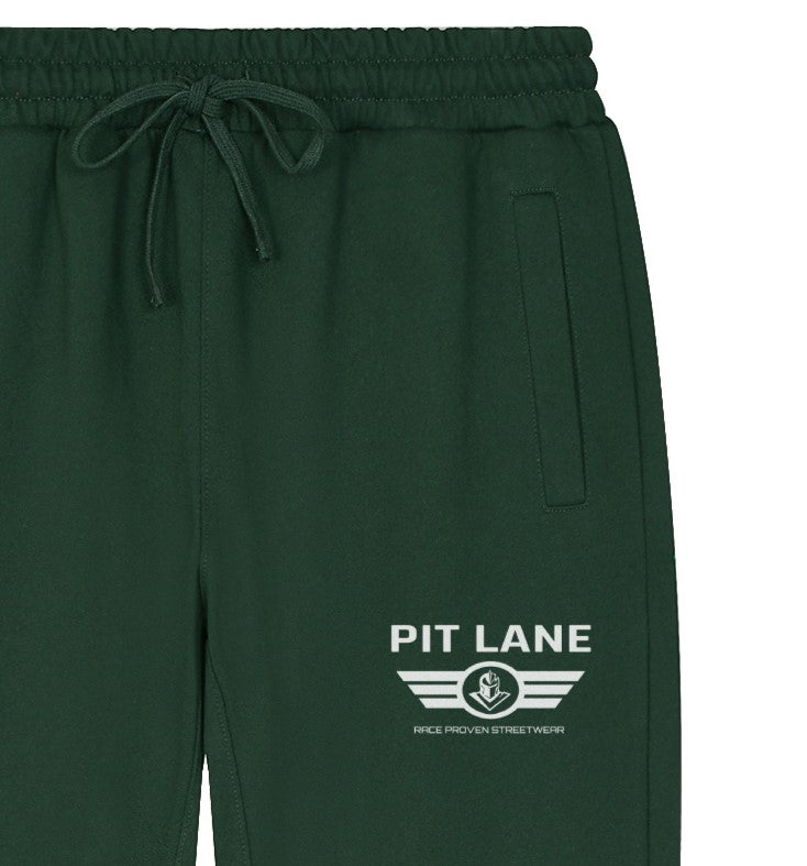 Dark green sweatpants with a white 'PIT LANE' winged logo printed on the left leg, featuring an elastic drawstring waist and side pocket.