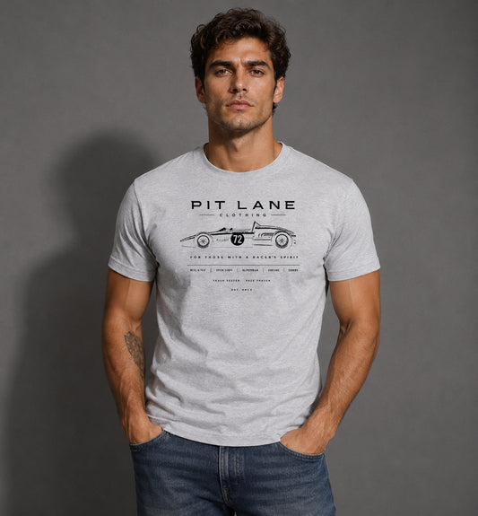 A man wearing a light gray heathered t-shirt with a black graphic print of a vintage race car and the text 'PIT LANE CLOTHING'.