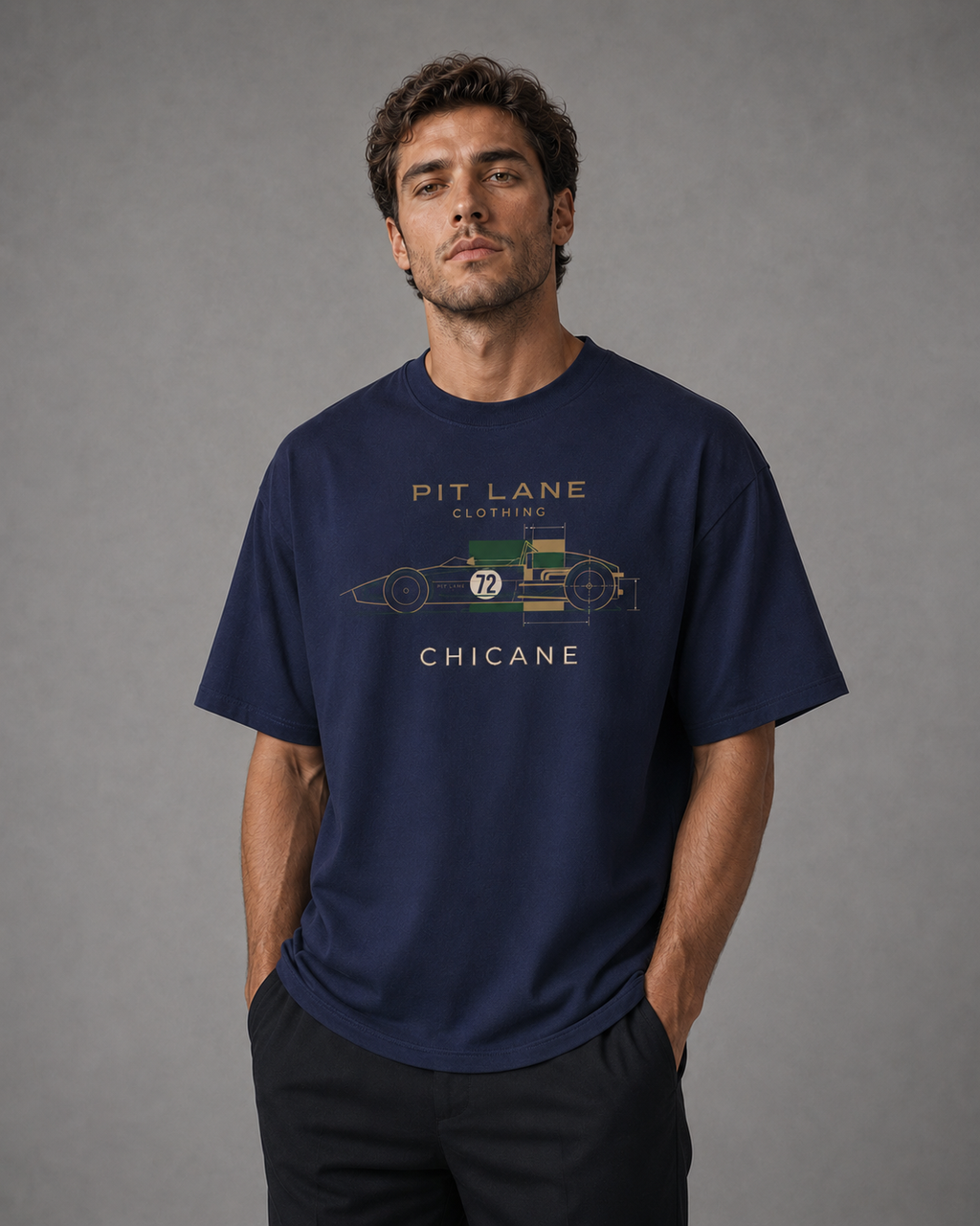 A man wearing a navy blue graphic t-shirt with a vintage race car design and the text 'PIT LANE CLOTHING' and 'CHICANE'.