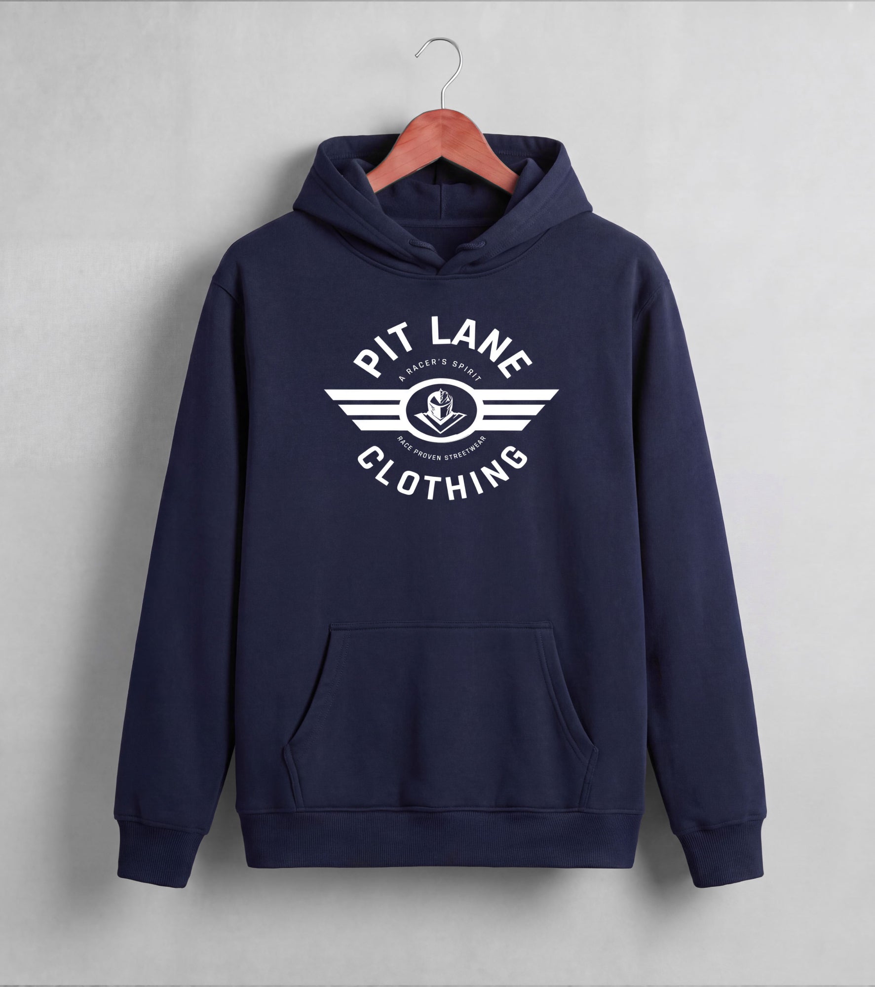 A navy blue pullover hoodie hanging on a wooden hanger against a light gray wall. The hoodie features a white graphic print on the chest that reads 'PIT LANE CLOTHING' with a winged anchor logo in the center.
