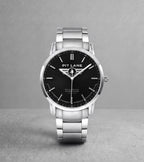 A silver-tone Pit Lane Clothing wristwatch with a black dial and matching silver-tone metal link bracelet, centered against a neutral gray background.