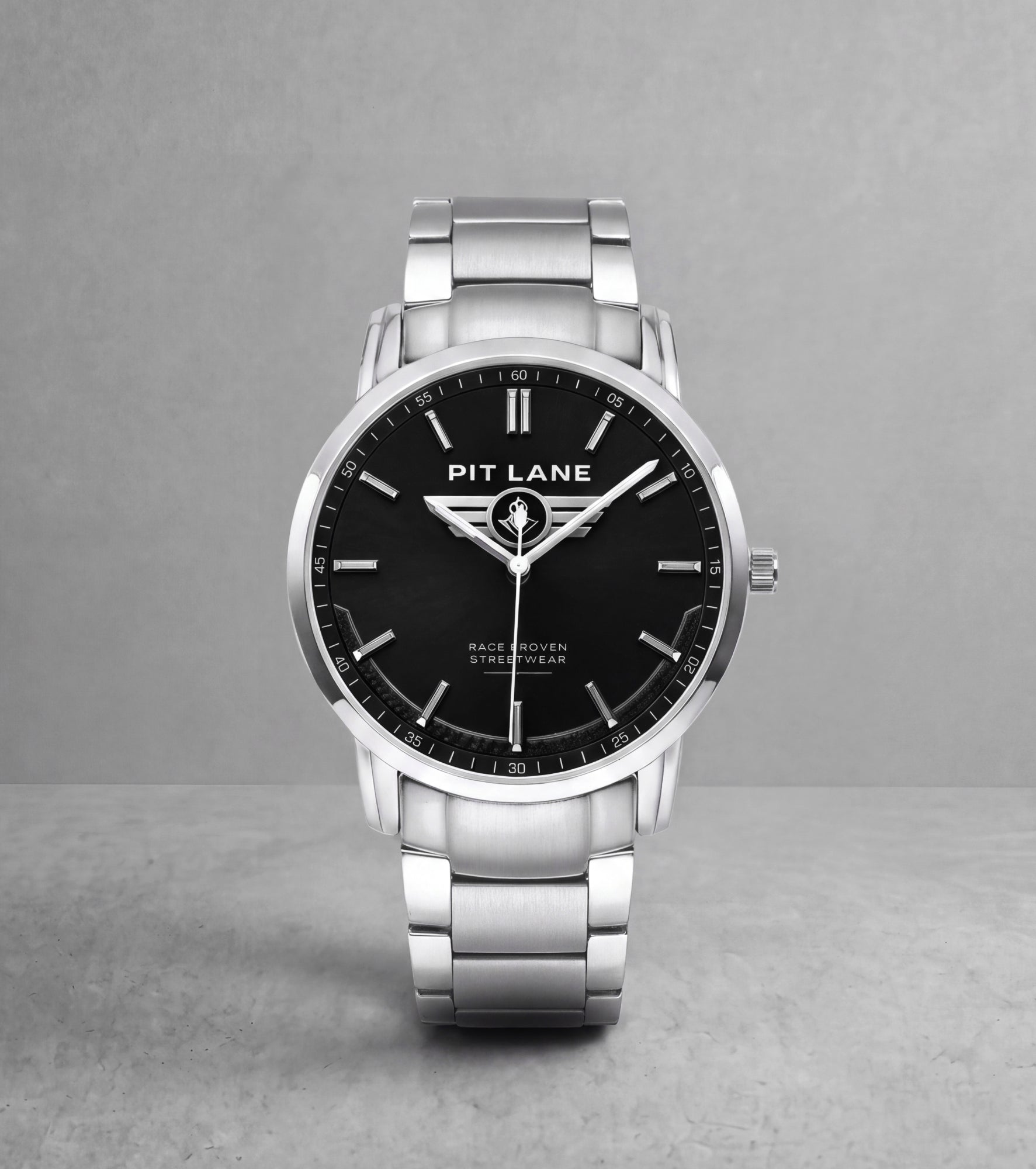 A silver-tone Pit Lane Clothing wristwatch with a black dial and matching silver-tone metal link bracelet, centered against a neutral gray background.