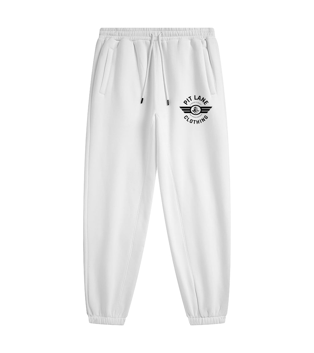 White sweatpants with a black circular winged logo on the left thigh that reads 'PIT LANE CLOTHING', shown against a plain white background.