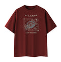 A dark red crewneck t-shirt with a white and gray graphic print on the front featuring a race car schematic and the text 'PIT LANE CLOTHING' and 'LAP RECORD'.