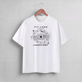 White short-sleeve t-shirt featuring a black graphic print of a race car in a technical blueprint design with the text 'PIT LANE CLOTHING' and 'A RACER'S SPIRIT'.