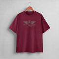 A maroon short-sleeve crewneck t-shirt hanging on a wooden hanger against a light gray wall. The shirt features a gray graphic on the chest with the text 'PIT LANE' and 'RACE DESIGN' under a winged emblem.