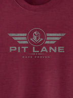 A close-up of a heathered maroon crewneck t-shirt featuring a distressed gray graphic on the chest with the text 'PIT LANE' and 'RACE PROVEN' beneath a winged helmet emblem.