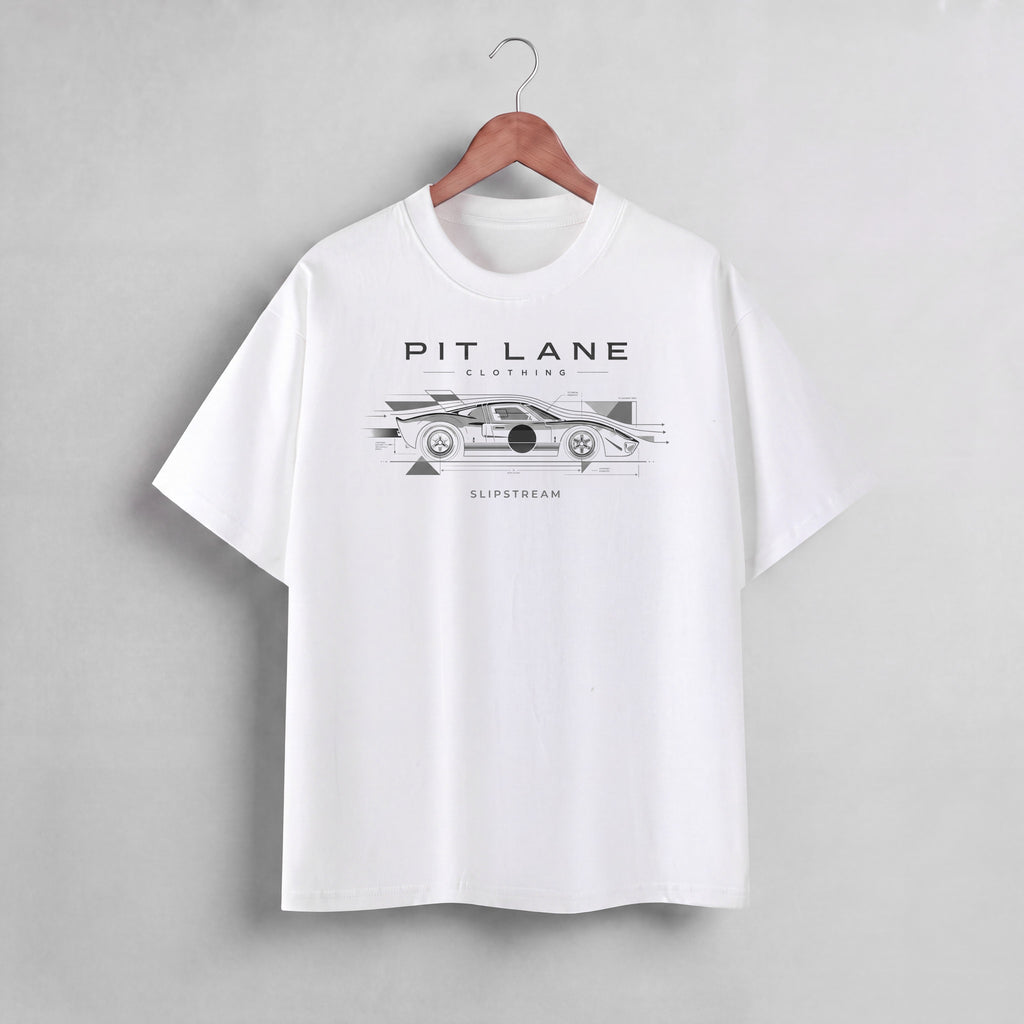 A white short-sleeve crewneck t-shirt hanging on a wooden hanger against a light gray wall. The shirt features a black graphic print of a race car with the text 'PIT LANE CLOTHING' and 'SLIPSTREAM' on the chest.